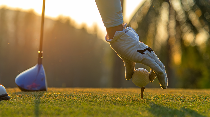 Ein Golfspieler legt seinen Ball auf einem Platz auf Rügen bereit zum Abschlag. © Adobe Stock, freebird7977